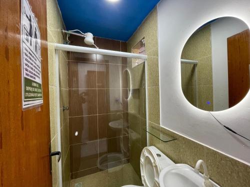 a bathroom with a sink and a mirror and a toilet at Pousada Bellmar Peró - Praia e Comércio 8 min andando in Cabo Frio