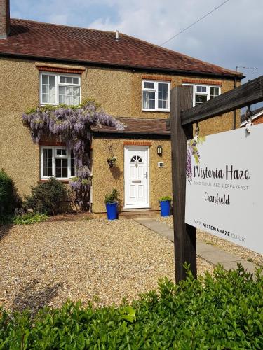 a house with a sign in front of it at Wisteria Haze in Cranfield