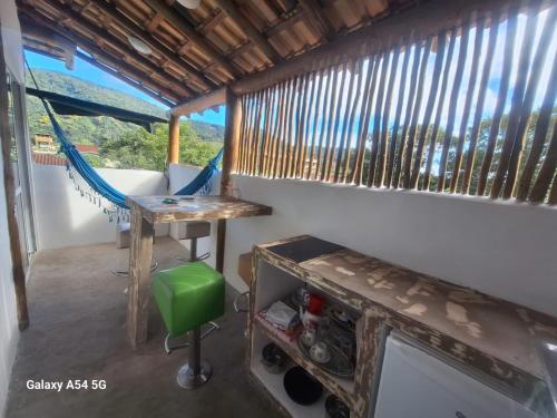 a room with a hammock and a table and a window at Alma Surf House in Boicucanga