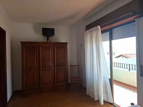 a living room with a sliding glass door with a television at Residência Livramento in Velas