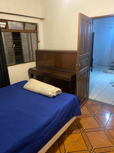 a bedroom with a bed and a piano at Casa 3 Quartos Espaço Luxemburgo in Anápolis