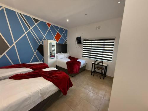 a hotel room with two beds and a window at Black & White Guest House in Parow