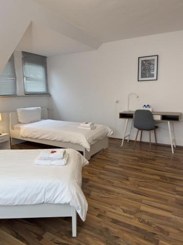 a room with three beds and a desk in it at Schönes Zimmer im Zentrum - 2 in Paderborn