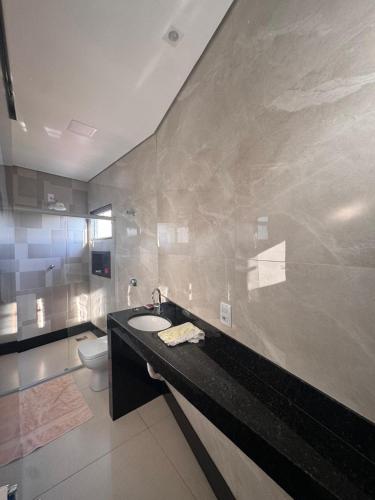 a bathroom with a sink and a toilet at Casa Hospedagem e Temporada Mobiliada in Sete Lagoas
