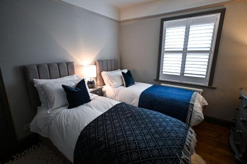 a bedroom with two beds and a window at Hythe House in Hythe