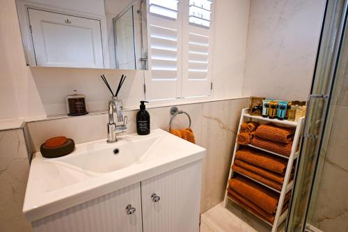a white bathroom with a sink and a shower at Hythe House in Hythe