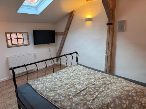 a bedroom with a bed and a flat screen tv at Speicherstübchen im alten Speicher in Schönberg