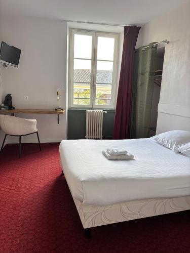a hotel room with a bed and a window at Santat Central hôtel in Bellac