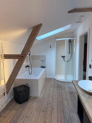 a bathroom with a shower and a tub and a sink at Speicherstübchen im alten Speicher in Schönberg