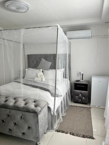 a bedroom with a canopy bed and a chair at Florino GuestHouse in Rundu