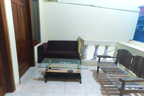 a living room with a couch and a glass table at Penginapan Barokah in Kemadang