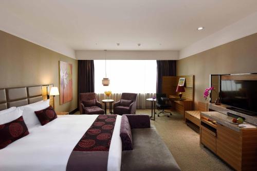a hotel room with a large bed and a living room at Fullon Hotel Taipei, Central in Taipei