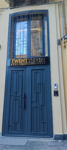 a blue door of a building with a sign on it at Twentyseven Luxury Suite in Catania
