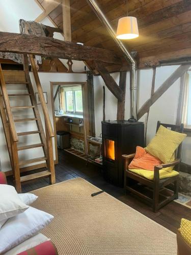 a room with a bunk bed and a wood stove at Secluded 17th Century converted barn in Midhurst