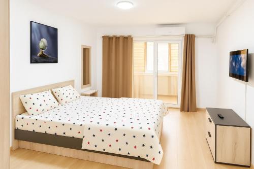 a bedroom with a bed with polka dots on it at Nicolle Cozy Apartment in Piteşti