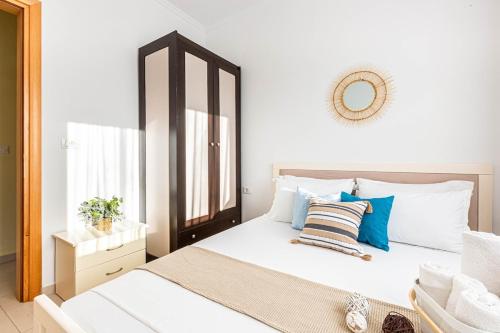 a bedroom with a large white bed with blue pillows at Shiny 2 Central Stay in Himare