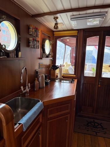 a kitchen with a sink and a counter top at Salonboot de Wending in Groningen