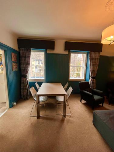 a living room with a table and chairs in it at Old Spittal Hospital Apartment - Free Parking in Stirling