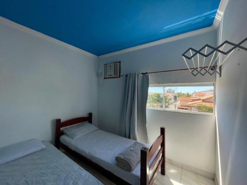 a bedroom with two beds and a window at Pousada Bellmar Peró - Praia e Comércio 8 min andando in Cabo Frio