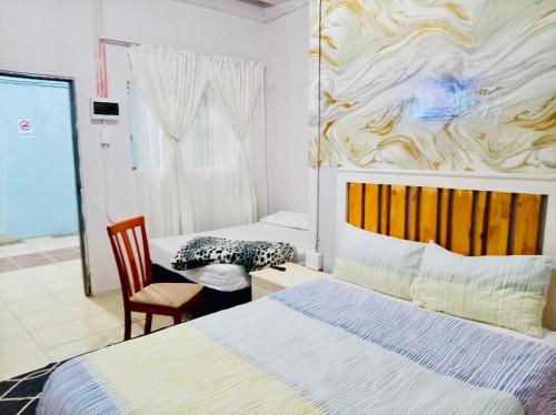 a hotel room with two beds and a chair at Blue Guesthouse in Virginia
