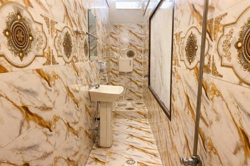 a marble bathroom with a sink and a shower at Amada Family Guest House in Karachi