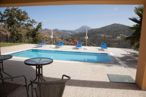 a pool with chairs and a table with a view at Villa Frati Gorge in Fratíon