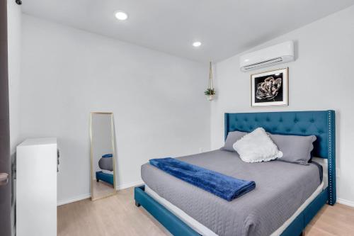 a bed with a blue headboard in a bedroom at The Container Retreat - 7A.. in Canyon Lake