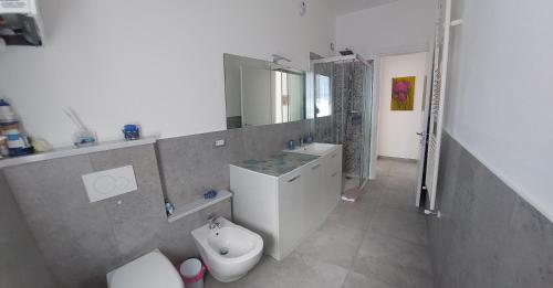 a bathroom with a toilet and a sink and a mirror at La Pineta, 26 - 3 in Casarza Ligure