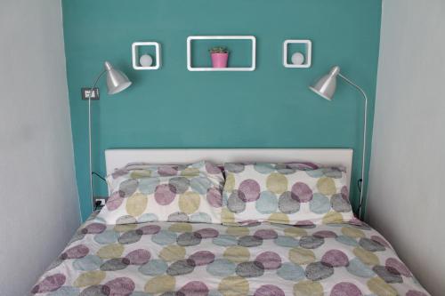 une chambre avec un lit avec une tête de lit bleue et deux lampes dans l'établissement Ca' del Mate, à San Giovanni Lupatoto