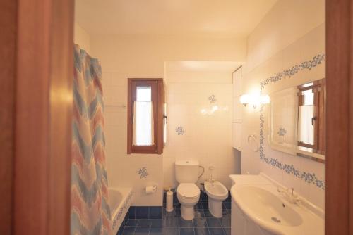 a bathroom with a toilet and a tub and a sink at Dual bay views by ΜΡS in Dhaskalión