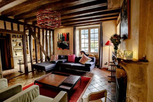 a living room with a couch and a table at Cité Plantagenêt, Jardin & piscine 24H du Mans in Le Mans