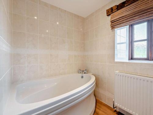 a bathroom with a white tub and a window at 4 Bed in Bridgnorth oc-oship in Highley