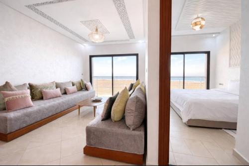 a living room with a bed and a couch and a window at Horizon bleu in El Jadida