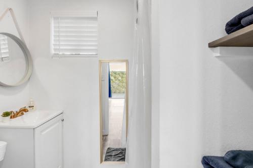 a white bathroom with a mirror and a sink at The Container Retreat - C11.. in Canyon Lake
