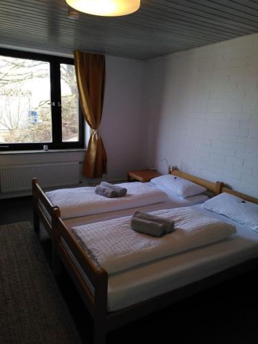 two twin beds in a room with two windows at Zimmer 12 in Gomadingen