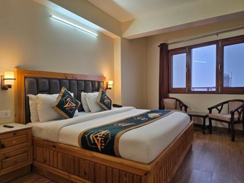 a bedroom with a large bed with a desk and a window at Kavin Uphar The Mall Road in Shimla