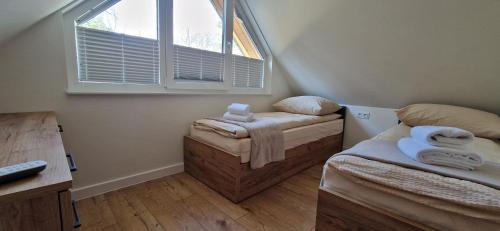 a small room with two beds and a window at TomHouse in Skorochow