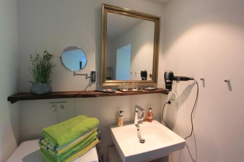 a bathroom with a sink and a mirror at Ferienwohnung Zirbentraum in Breitbrunn am Chiemsee