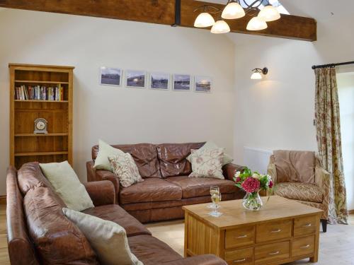 a living room with a couch and a coffee table at Sgubor Ucha in Trefriw