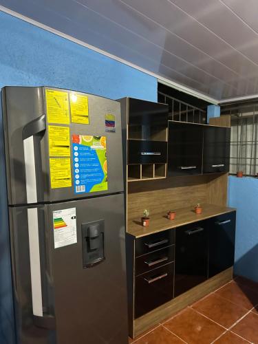a kitchen with a stainless steel refrigerator and a counter at GuestHouse Detours CR in Fortuna