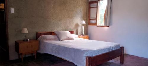 a bedroom with a white bed and a window at Autóctona in Villa Cura Brochero