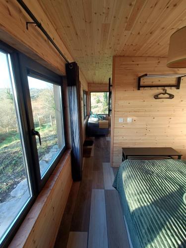 a room with a bed and windows in a train at The Nest - Secluded Cabin with Panoramic Views in Gurteenulla