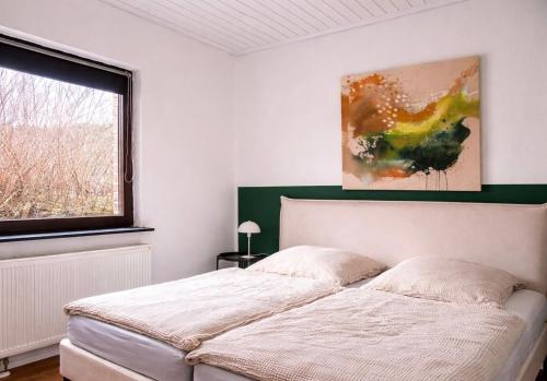 a bedroom with a bed and a painting on the wall at Ferienhaus Wacholder in Mechernich