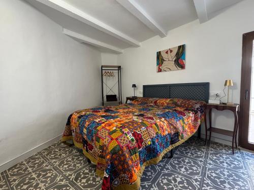 a bedroom with a bed with a colorful bedspread at Casa Lui Codrut in Alcalà de Xivert