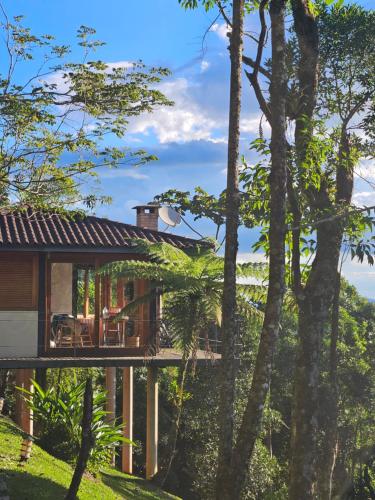a house with a wrap around deck in the woods at Alto de Santa Barbara in São Francisco Xavier