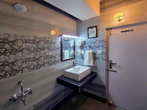 a bathroom with a sink and a mirror at Kavin Uphar The Mall Road in Shimla