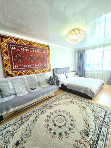 a bedroom with two beds and a rug at Аэропорт-Астана двухкомнатная in Astana