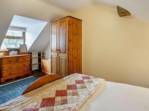 a bedroom with a bed and a wooden cabinet and a dresser at 1 Bed in Brecon oc-bn367 in Bwlch