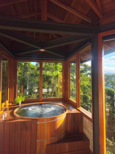 a hot tub in a room with windows at Alto de Santa Barbara in São Francisco Xavier