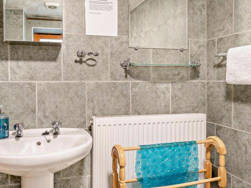 a bathroom with a sink and a mirror and a chair at 2 Bed in Brecon oc-bn138 in Bwlch